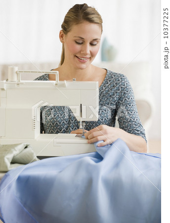 Woman using sewing machine 10377225