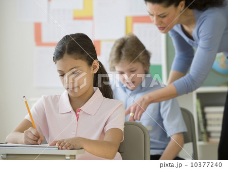 Hispanic girl writing at school desk Hispanic girl writing at school desk 10377240
