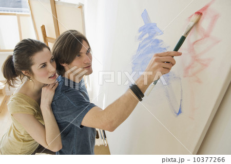 Woman watching boyfriend paint on easel Woman watching boyfriend paint on easel 10377266