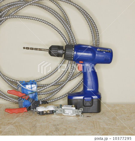 Cordless drill next to wire cutters and cable 10377295
