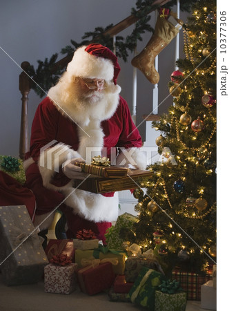 Santa Claus leaving gifts under Christmas tree 10377306