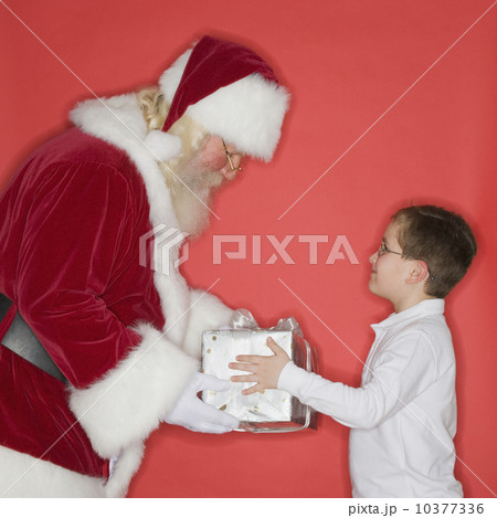 Santa Claus handing gift to boy 10377336
