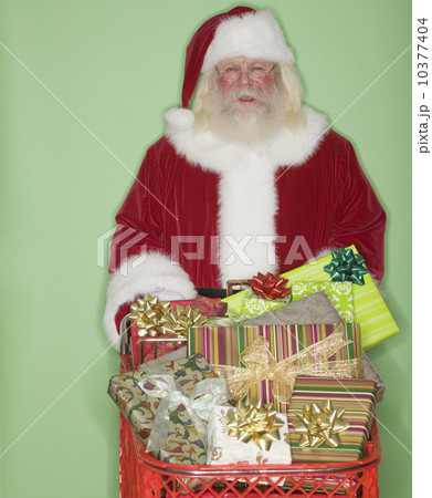 Santa Claus pushing shopping cart of gifts 10377404