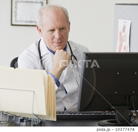 Senior male doctor looking at computer 10377478