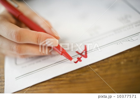 Teacher writing A plus grade on worksheet Teacher writing A plus grade on worksheet 10377571