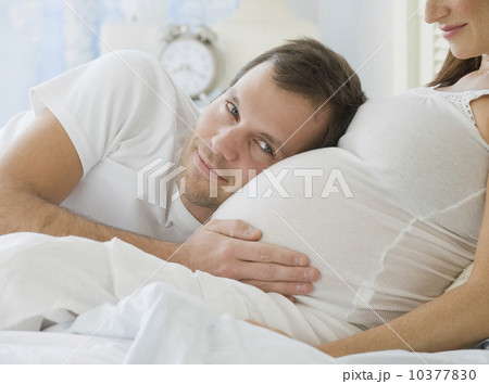 Hispanic man resting head on pregnant wife Hispanic man resting head on pregnant wife 10377830