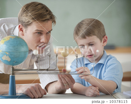 Teacher and student looking at globe 10378115