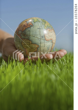 Close up of hand holding globe in grass Close up of hand holding globe in grass 10378264
