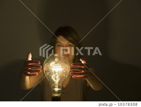 Woman holding hands around large light bulb 10378308