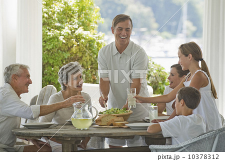 Multi-generational family eating on porch 10378312