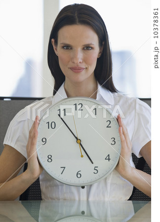 Portrait of businesswoman holding clock Portrait of businesswoman holding clock 10378361