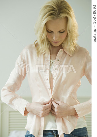 Woman buttoning shirt 10378693