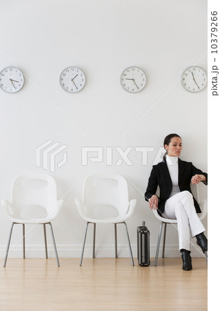Businesswoman looking at wrist watch in waiting room 10379266