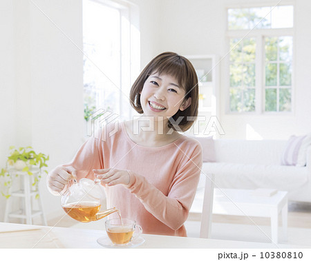 紅茶を注ぐ女性の写真素材