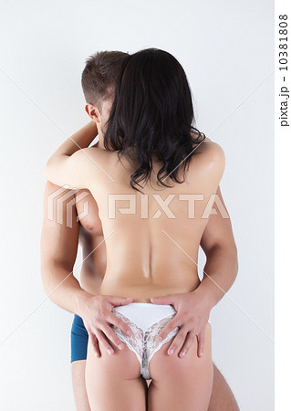 Rear view of young people embracing in studio Rear view of young people embracing in studio 10381808