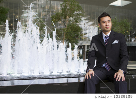 Portrait of Asian business man sitting beside a water fountain Portrait of Asian business man sitting beside a water fountain 10389109