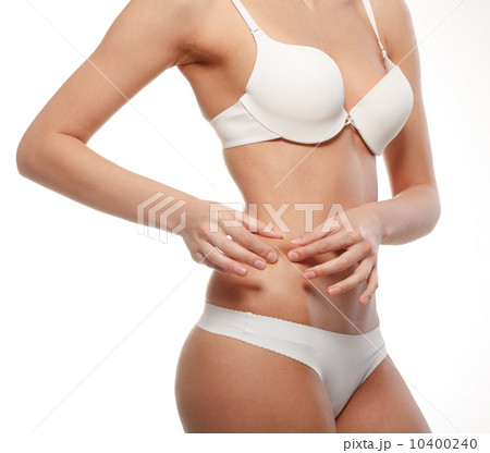 Young woman checks excess weight in their waist. 10400240