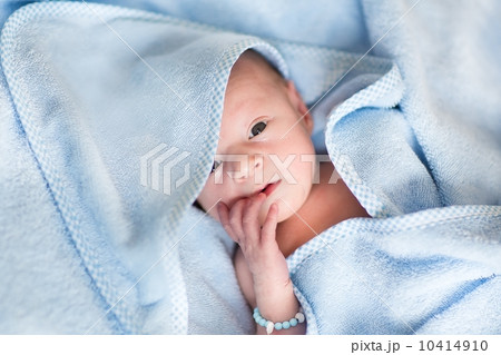 Newborn baby relaxing after a bath in a blue towel 10414910