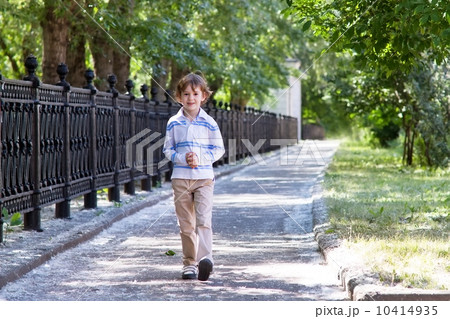 Little boy walking on a sunny street Little boy walking on a sunny street 10414935