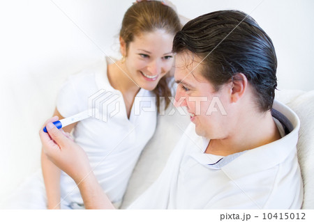 Young happy couple looking at a positive pregnancy test 10415012