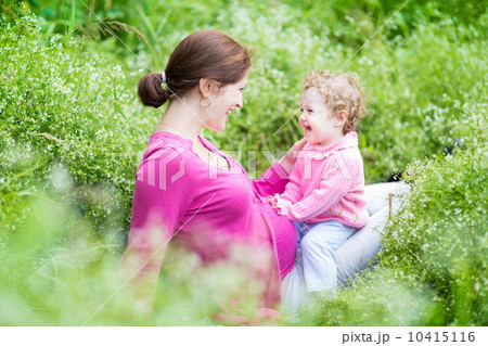 Laughing young pregnant mother playing with her one year old bab Laughing young pregnant mother playing with her one year old bab 10415116