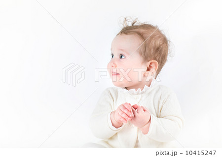 Profile of a cute baby girl in a white knitted cardigan 10415247