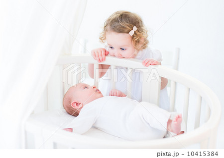 Cute newborn baby boy watching his toddler sister standing at hi Cute newborn baby boy watching his toddler sister standing at hi 10415384