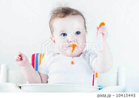 Adorable baby girl eating vegetables for the first time 10415443