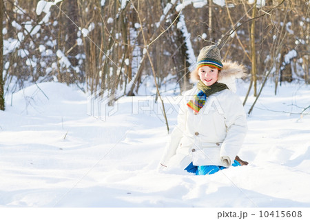 Happy child playing in a snow field on a sunny winter day Happy child playing in a snow field on a sunny winter day 10415608
