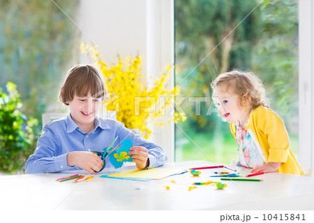 Two kids, happy teenager boy and his cute toddler sister, having 10415841