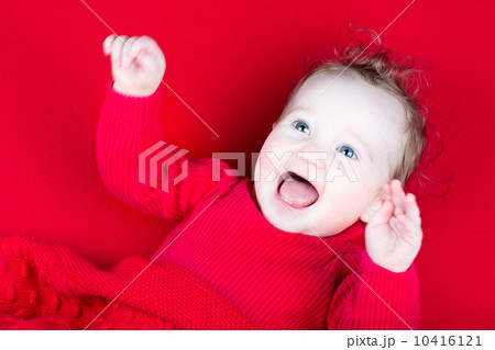 Laughing playing baby girl under a red blanket Laughing playing baby girl under a red blanket 10416121