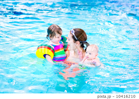 Young mother having fun in a swimming pool with a toddler girl a 10416210