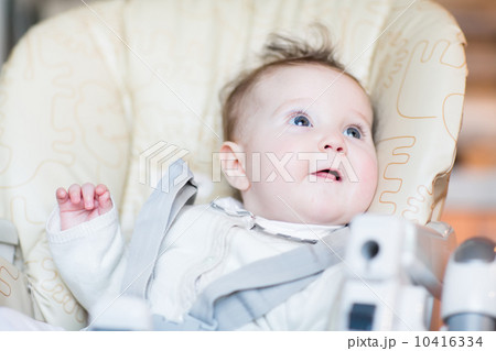 Sweet baby girl waiting for dinner in a high chair 10416334