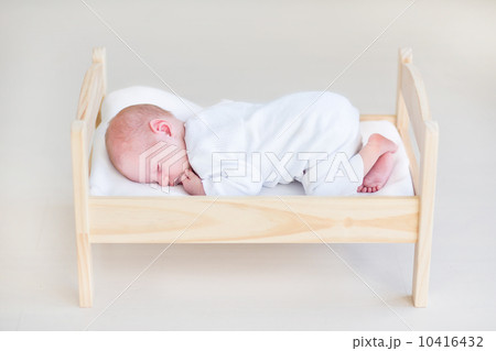 Cute sleeping newborn baby in a toy bed 10416432