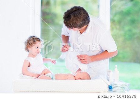 Little toddler girl helping her father to choose an outfit for h 10416579