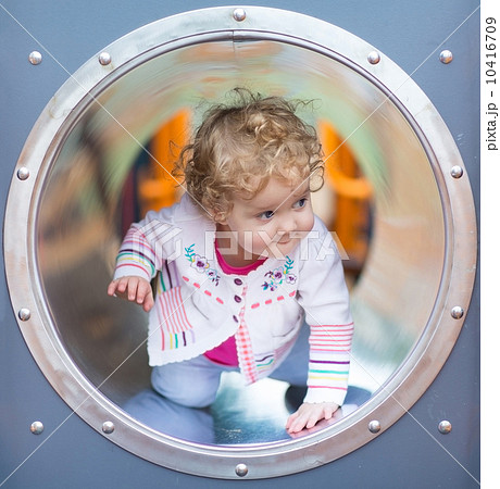 Adorable funny baby girl hiding on a playground 10416709