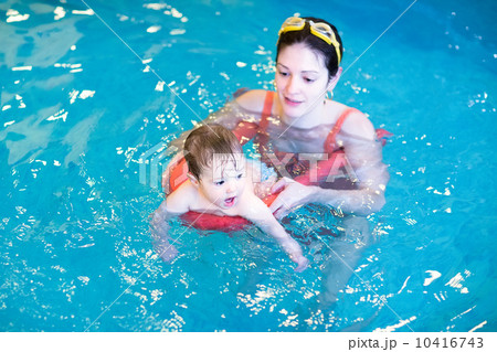 Little baby swimming in a pool with her mother 10416743