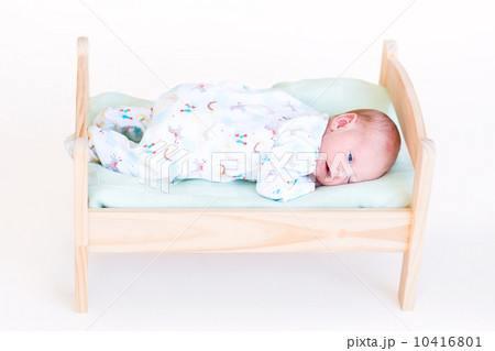 Funny newborn baby in a toy bed Funny newborn baby in a toy bed 10416801