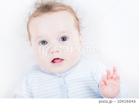 Little baby in a blue knitted sweater watching attentively 10416848
