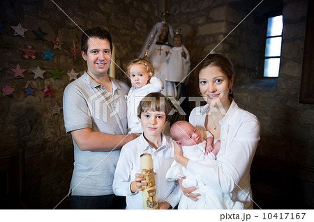 Happy young family with three children celebrating the baptism o 10417167
