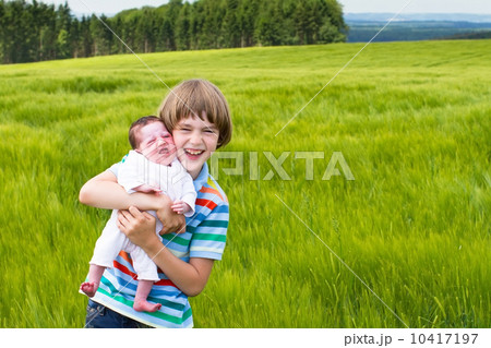 Little boy holding his newborn sister 10417197