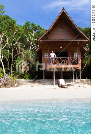 Mature man watching the ocean from a tropical bungalow 10417246