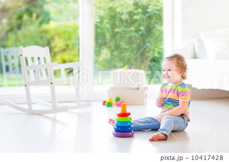 Adorable toddler girl playing in a beautiful white room with a b Adorable toddler girl playing in a beautiful white room with a b 10417428