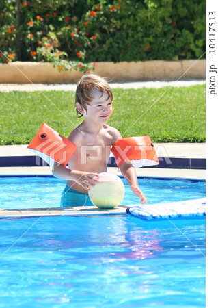 Little boy playing with a ball in a swimming pool Little boy playing with a ball in a swimming pool 10417513