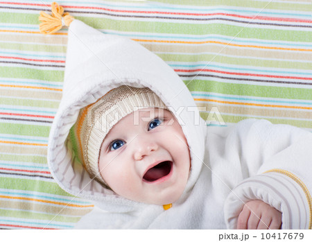 Beautiful little baby with big blue eyes wearing a warm hat and 10417679