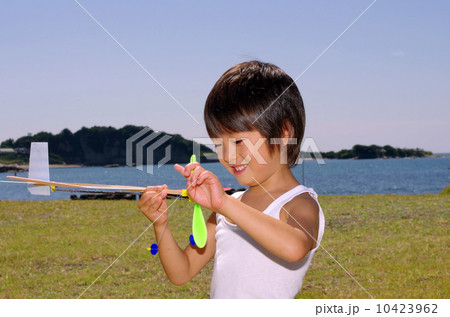 海岸で模型飛行機を飛ばす子供 10423962