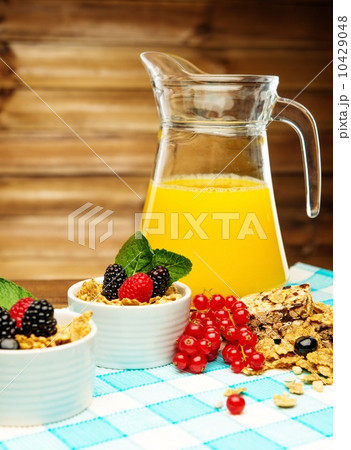 Healthy breakfast with fresh orange juice on tablecloth in wooden rural interior 10429048