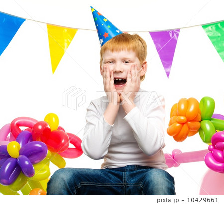 Surprised little redhead boy among birthday balloons 10429661