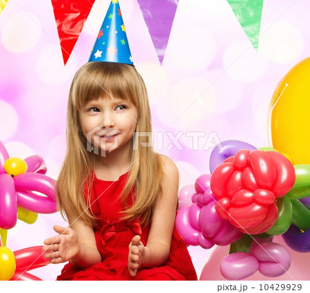 Little girl in red dress sitting on gift boxes 10429929