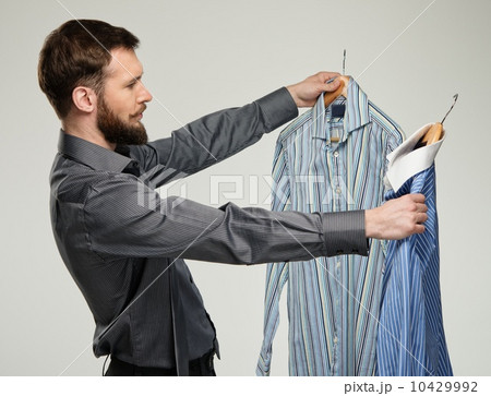 Handsome man with beard choosing shirt Handsome man with beard choosing shirt 10429992